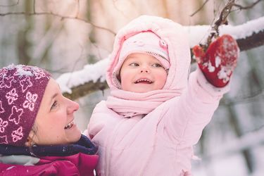 Mutter und Kleinkind bei einem Spaziergang im Winter-Wald