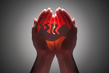 schnitt eines Babys mit Lichtkegel dahinter
