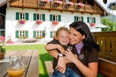 Mutter umarmt ein Kind am Bauernhof