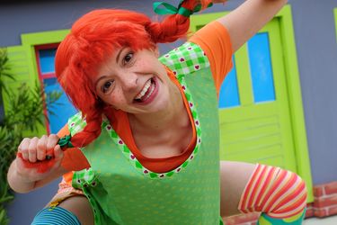 Schauspielerin verkleidet als Pippi Langstrumpf mit roten Zöpfen