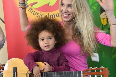 Mädchen spielt Gitarre mit einer Betreuerin