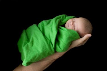 Baby wickelt in ein Handtuch gehüllt in der Hand der Mutter